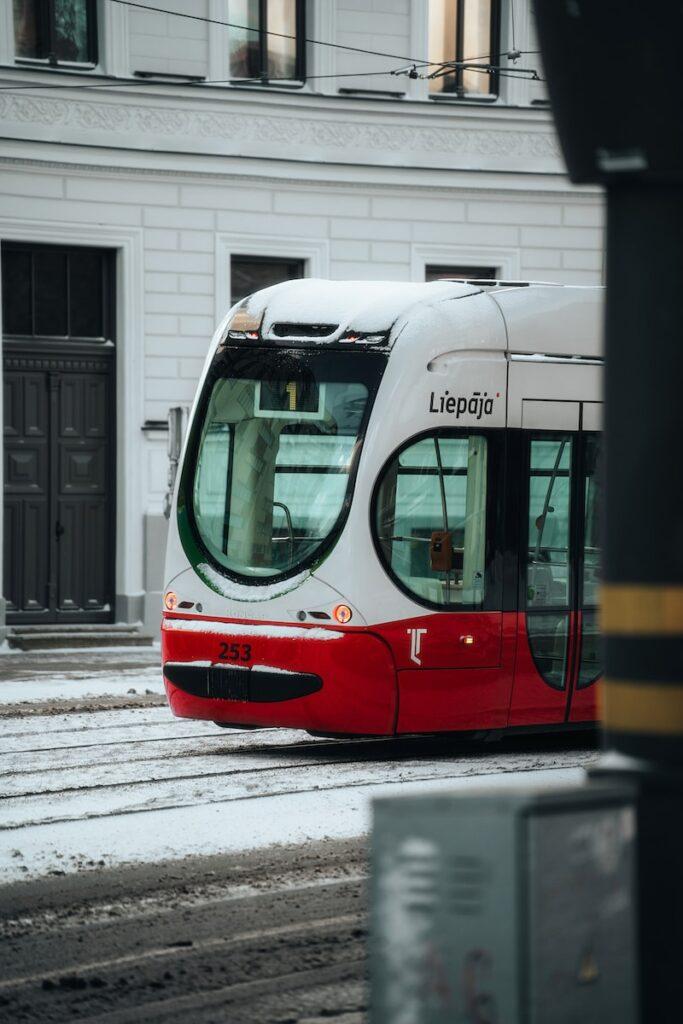 a red and white bus driving down a street